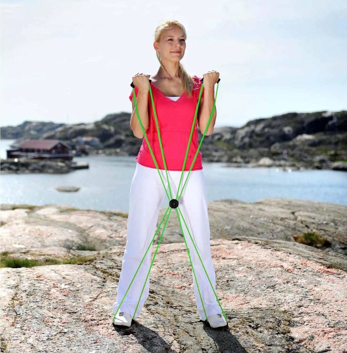 A woman exercising with a multi-strand resistance band.