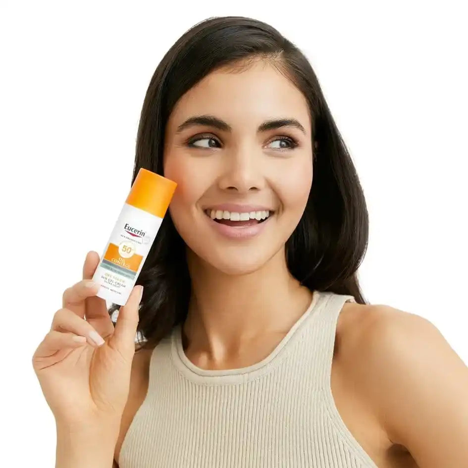 A woman holding a bottle of sunscreen with SPF 50.