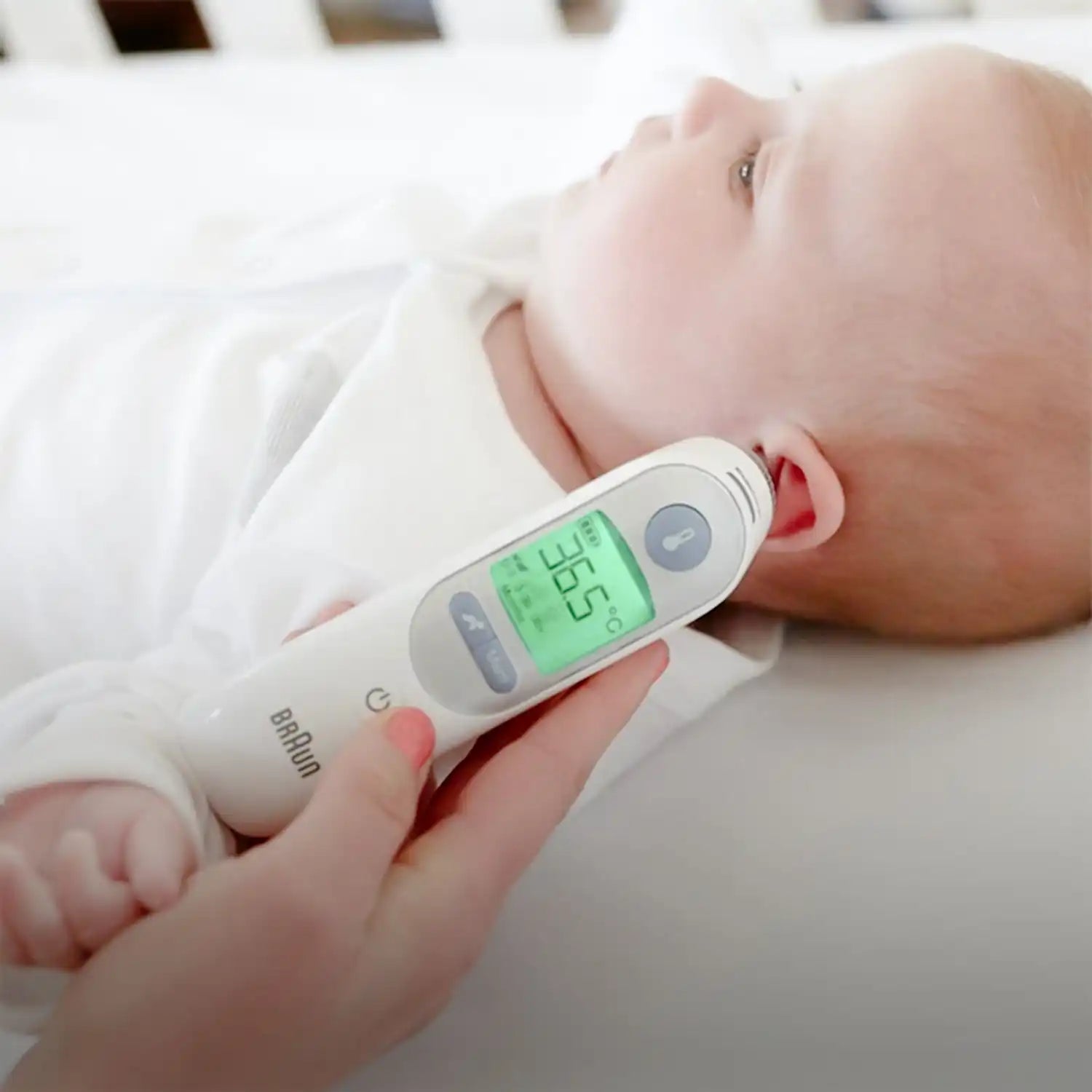 Braun ear thermometer with digital display, white and pink accents.