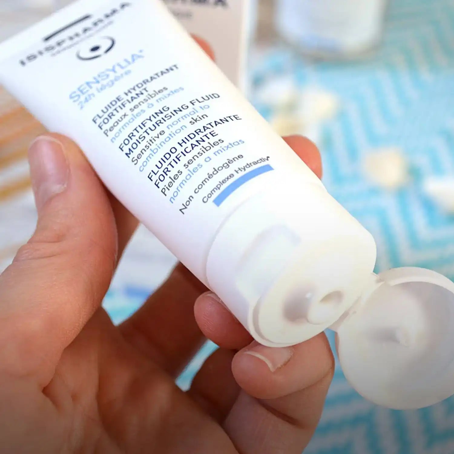 White tube of moisturizing fluid with pump dispenser, labeled ’sensyva fortifying moisturizing fluid’ by isispharma.