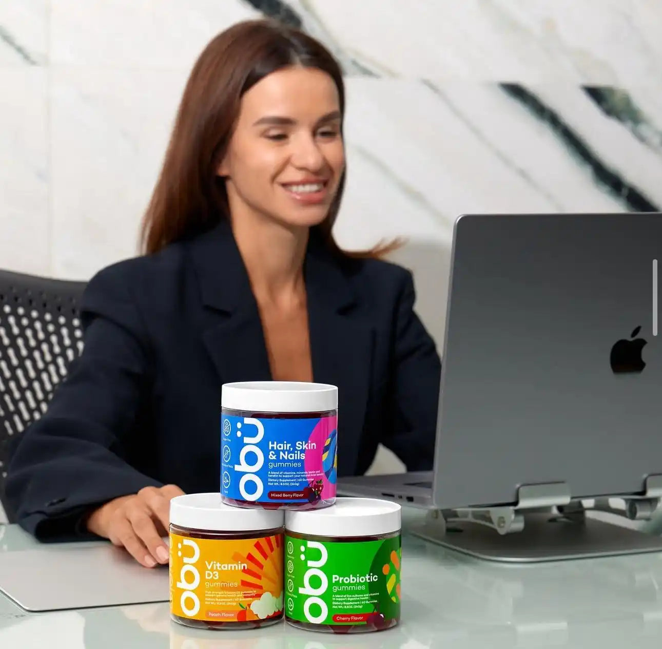Three tubs of chewable vitamin supplements, with colorful labels, stacked on a desk.