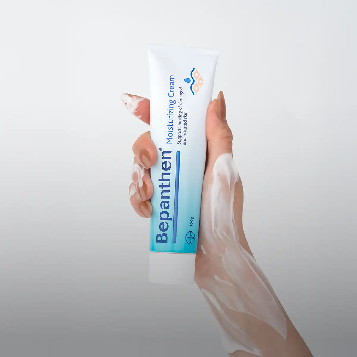 A white and light blue tube of bepanthen moisturizing cream, 100g.