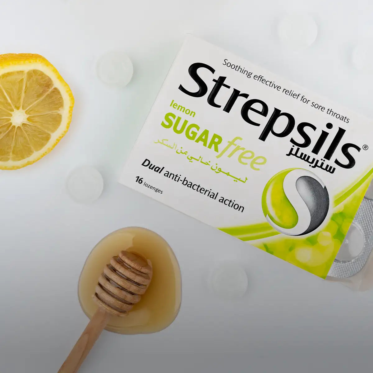 Lemon-flavored sugar-free strepsils lozenges in a white and green box with arabic text, featuring dual anti-bacterial action.