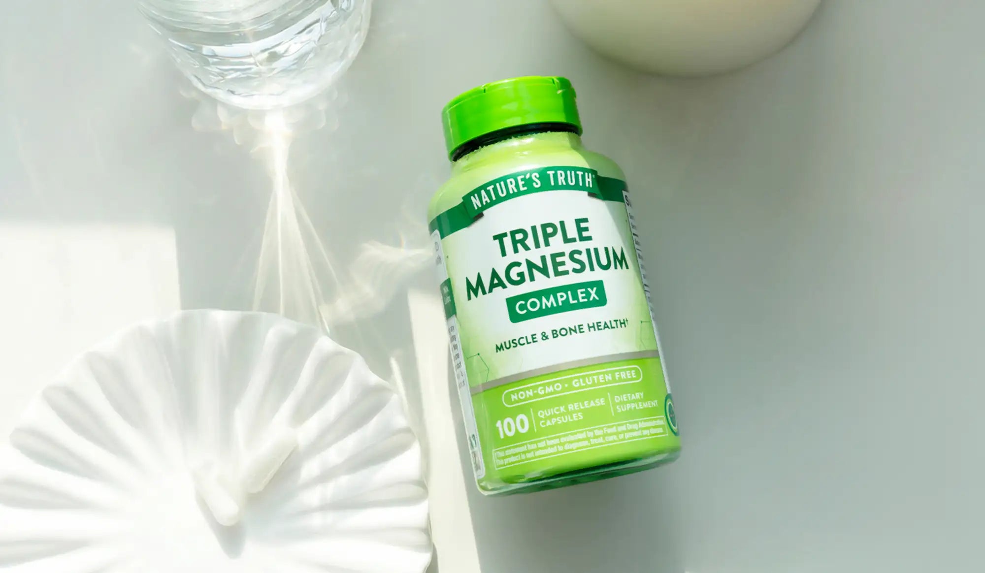 A green bottle of nature’s truth triple magnesium complex supplements with a matching cap, labeled for muscle and bone health.