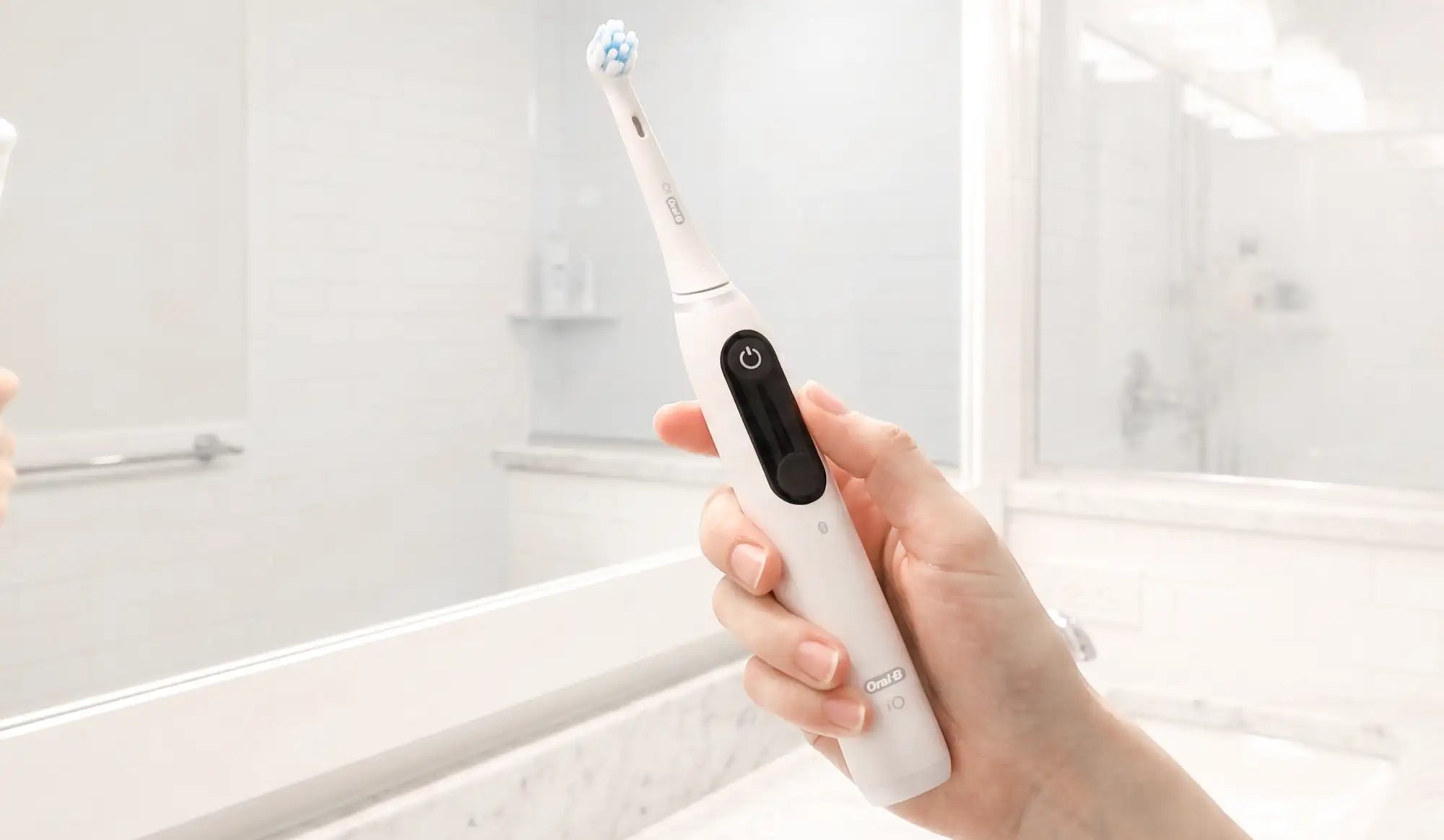 White oral-b electric toothbrush with a sleek, modern design and a black power button on the handle.