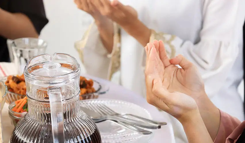 Clear glass pitcher with a ribbed body and handle, filled with dark liquid.