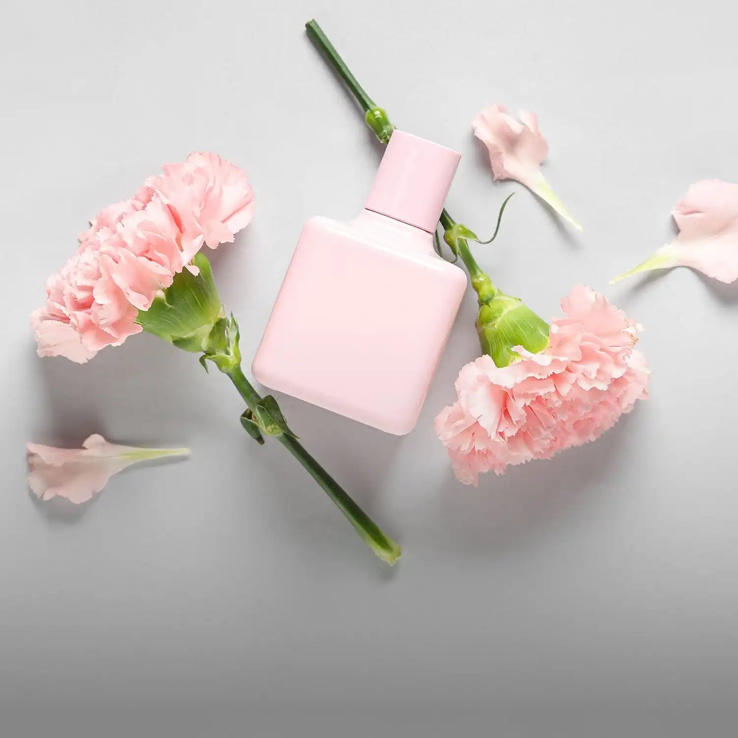 Pastel pink perfume bottle with a square shape and matte finish, likely made of glass or plastic.