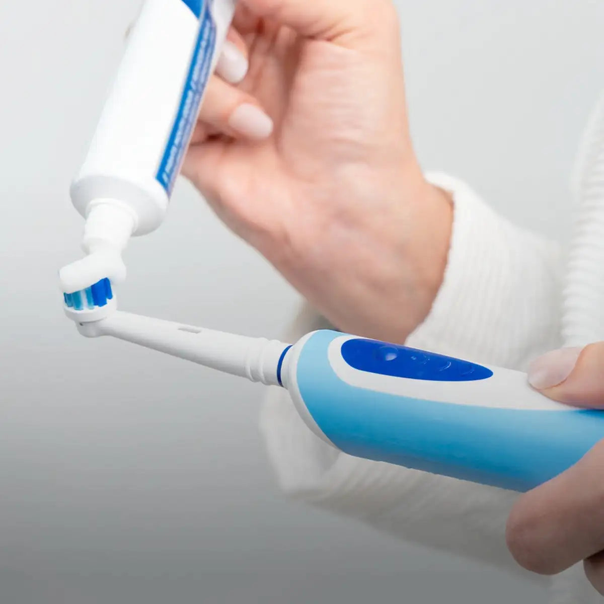 Blue and white electric toothbrush with a sleek, ergonomic design.