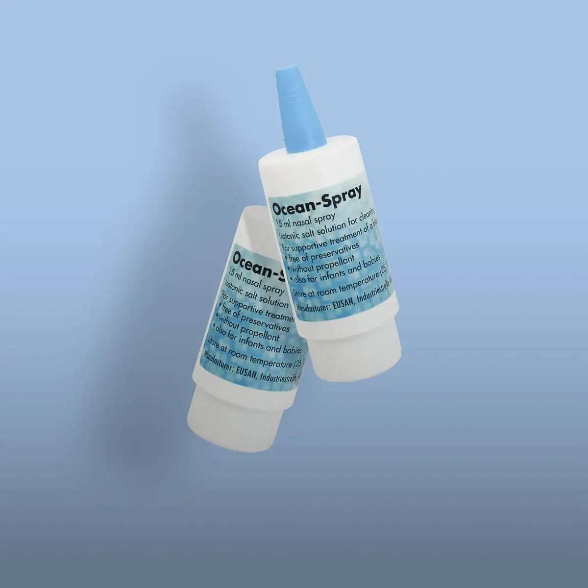Two white plastic bottles of ocean-spray nasal spray with blue caps and labels, each containing 15 ml of isotonic salt solution.