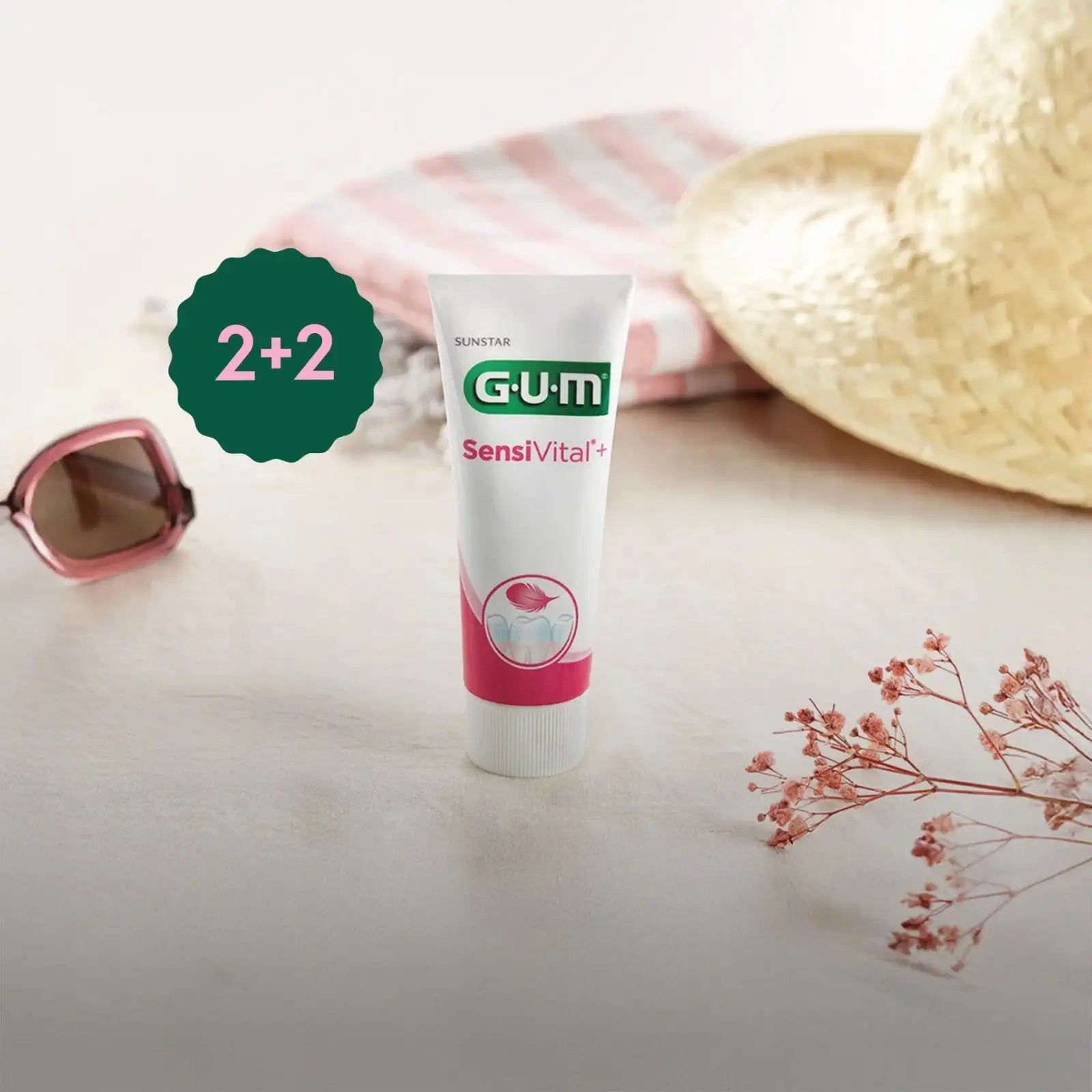 A white and pink gum sensivital+ toothpaste tube with a green logo, featuring a dental health illustration on its label.